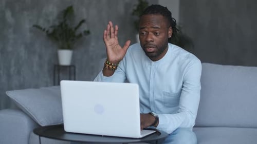 Man Waving at Laptop and Working from Home