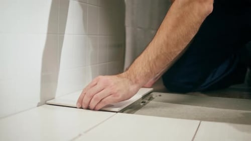Adult Laying Down White Tiles Close Up