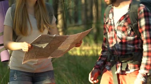 Couple Hiking Together in a Forest with Map