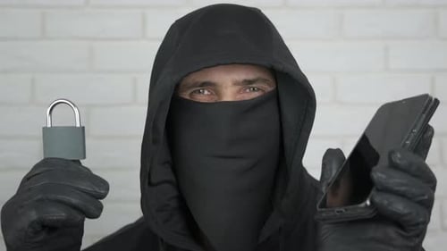 Man Wearing Hood Holding Phone and Padlock