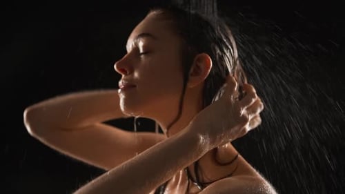 Beautiful Girl Standing Under Shower Isolated Over White Background in Slowmotion