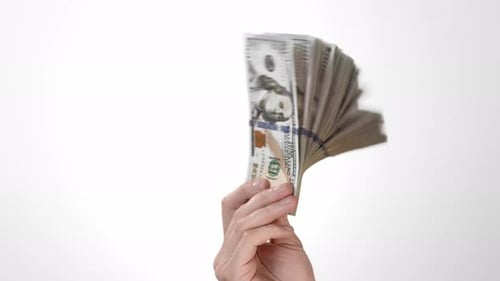 Hand on a White Background of Isolate Holds One Hundred Dollar Bills and Moves a Stack of American