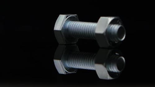 Metal Nut Screwed on Screw Turn on Black Background Studio