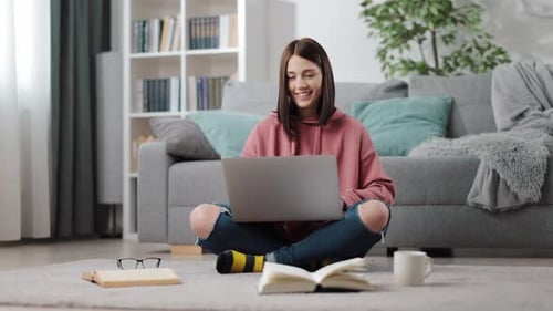 Woman Using Laptop While Sitting on Floor