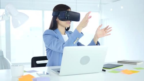 Young Woman Uses VR Headset at Office Desk