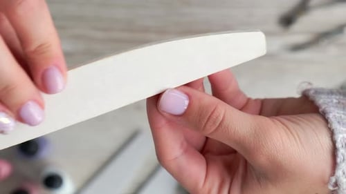 Woman Filing Nails with a Nail File Close Up