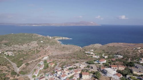 Drone aerial view of Mediterranean village beach on Crete, Greece. Hotel, vacation, travel concept.