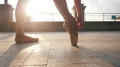 Close Up of a Ballet Dancer's Feet As She Corrects Pointe on the Stone Embankment. Woman's Feet in