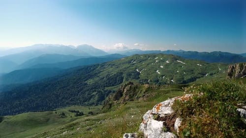 Morgenblick vom Stein des schönen grünen Tals mit wildem Wald und Bergsilhouetten im sonnigen