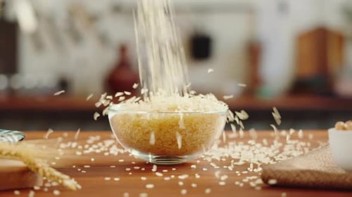 Rice Grain Pouring into a Clear Glass Bowl