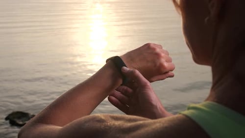 Woman Checks Smart Watch at Water's Edge