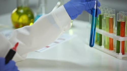 Tube d'inscription d'assistant de laboratoire avec l'échantillon détergent bleu, essai de substance de lavage