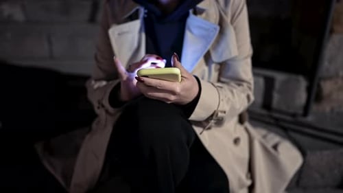 Young Woman Using Smartphone on Night City Street