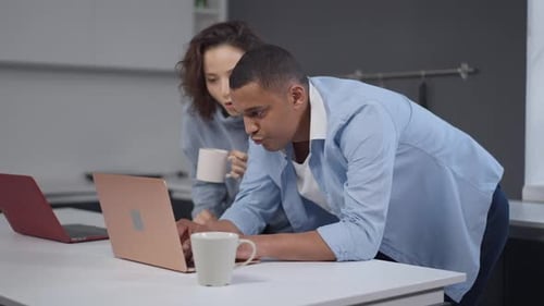 Man and Woman Use Laptop Together