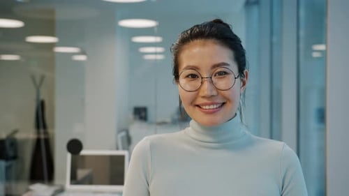 Portrait of Attractive Asian Businesslady Wearing Glasses Smiling in Office