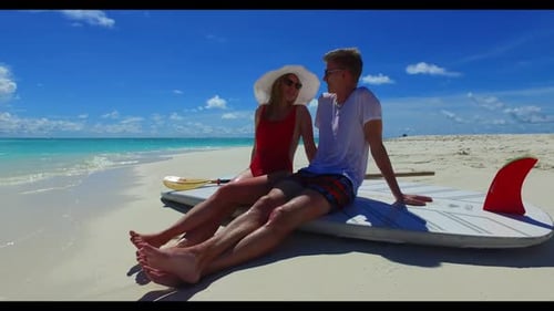 Man and lady engaged on exotic seashore beach holiday by blue ocean with white sandy background of t