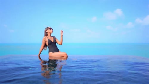 Young asian woman enjoy around outdoor swimming pool for leisure