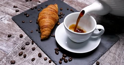 Coffee Pouring into Cup with Fresh Croissant
