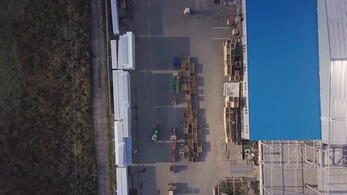 dos cargadores están transportando palets con manzanas en el almacén para su posterior transporte