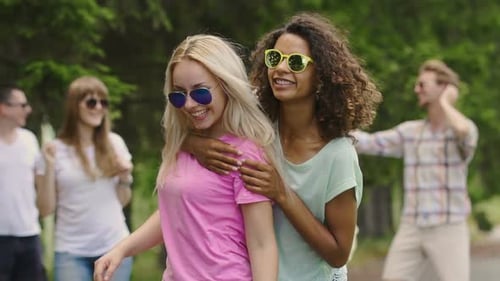 Dos mujeres multirraciales bailando alegremente al aire libre, jóvenes disfrutando de fiesta