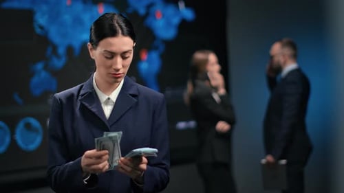 Woman Counts Money at Workplace with Colleagues