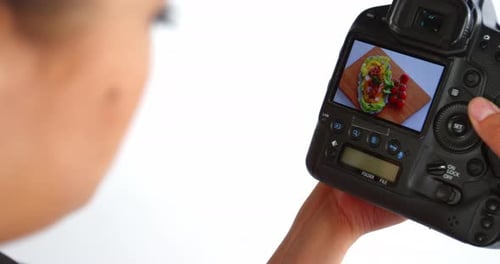 Photographer looking at photos on digital camera