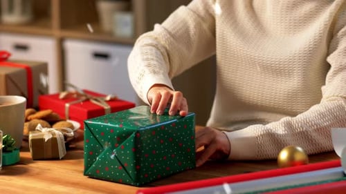 Woman Wrapping Christmas Gifts at Home