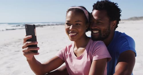 African american couple smiling taking selfie with smartphone on the beach