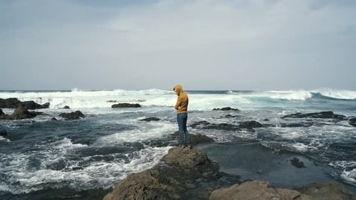 Tourist im gelben Sweatshirt spaziert am Vulkanstrand im Norden der Kanareninsel Teneriffa