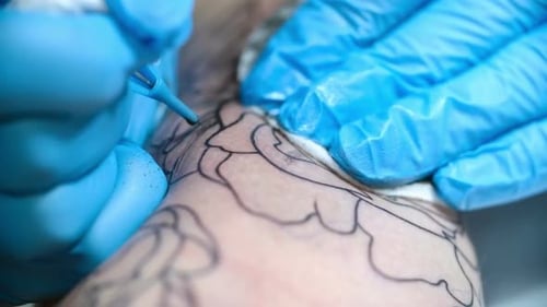 Tattoo Artist Creating Floral Tattoo Design