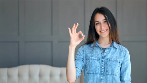 Smiling Woman Gives OK Sign in Studio