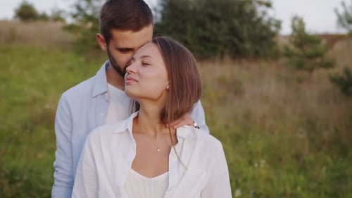 Closeup of a Beautiful Girl and Boy Hugging in a Park