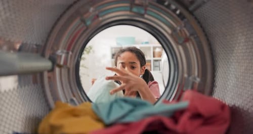 Inside the Washing Machine a Little Girl Opens the Door and Puts Colorful Clothes Into the Drum She