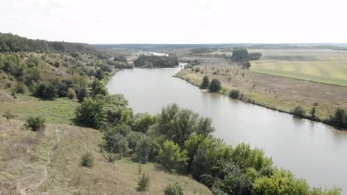 Beautiful aerial landscape in rural countryside with river and harvest green fields