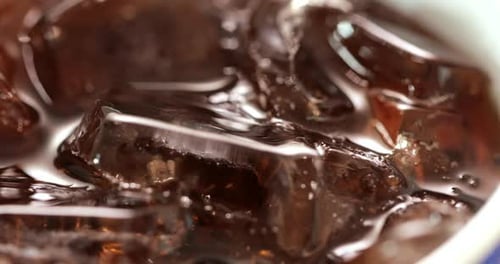 Ice Cubes Floating in a Dark Drink
