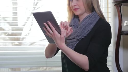 Woman Using Tablet Device Indoors During the Day
