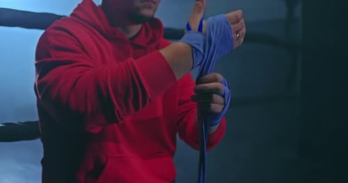 Athlete Wrapping Hands for Boxing Training in Gym