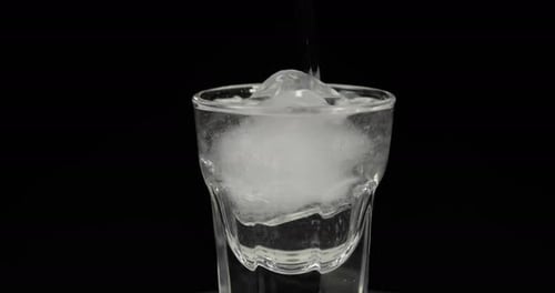 Ice Cube and Water in a Clear Glass