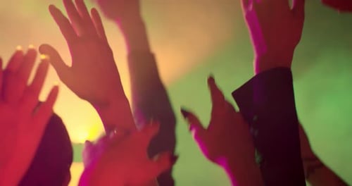 People Dancing with Raised Hands at Neon Party