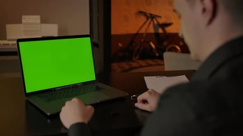 Young Adult at Laptop with Green Screen