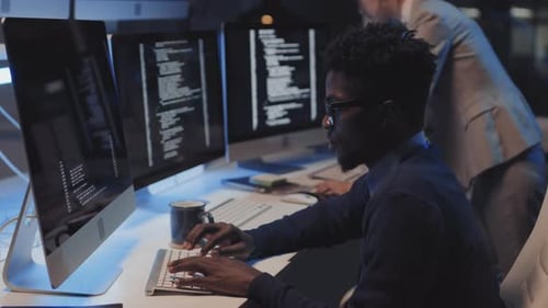 Man Coding in Office at Night