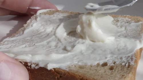 Spreading Cream Cheese on Bread for Breakfast