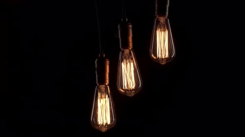 Three Retro Lamps Hang and Turn on at the Same Time on Black Background. Antique Bulbs with Old Lamp