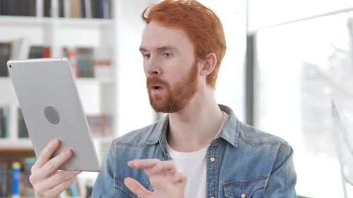 Excited Man Celebrating Success Using Tablet Device