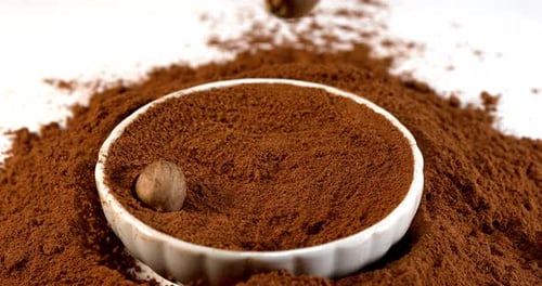 Nutmeg and Powder Falling Into Bowl