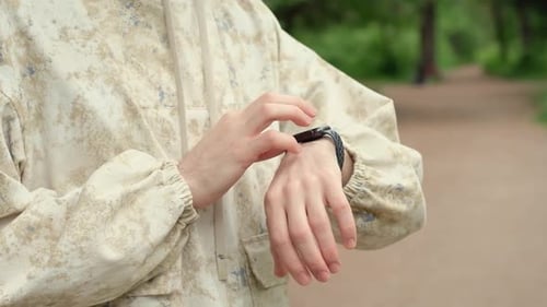Young Adult Using Smartwatch in Urban Green Space