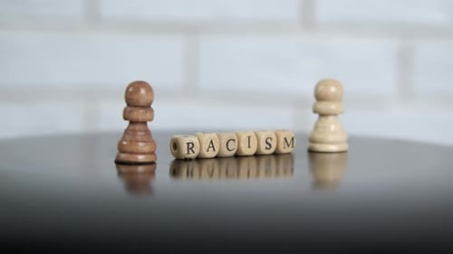 Chess Pieces with Racism Spelled Out on Blocks
