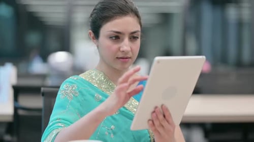 Woman Working on Tablet in Office Environment