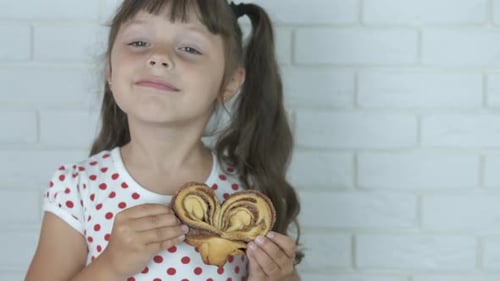 Child Holds Palmier Pastry Heart Shape Close Up