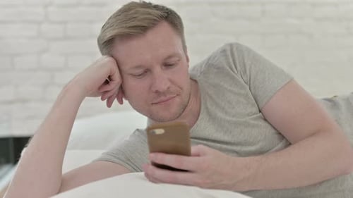 Close Up of Man Using Smart Phone While in Bed
